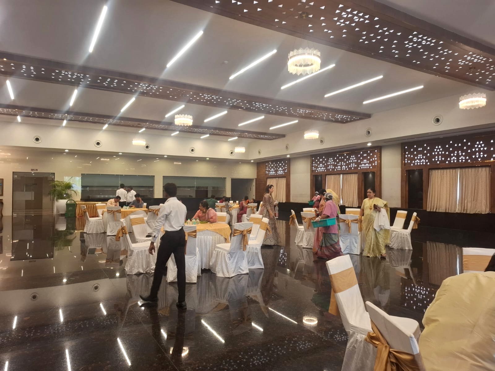 Guests seated at draped dining tables in a banquet hall during a function catered by Sri Amrutha in Tirupati
